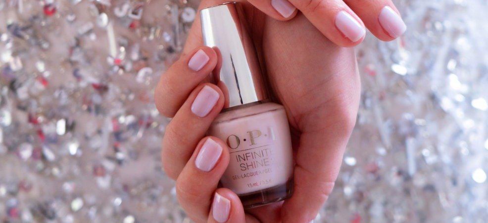 Una mujer sosteniendo una pintura de uñas de la firma de OPI