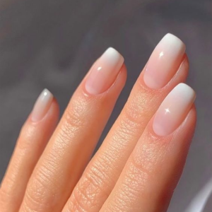 Una persona muestra sus uñas despues de un servicio de acabado Baby Boomer Acrílico