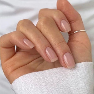 Una mujer muestra sus uñas luego de un servicio de megabase para reforzar las uñas