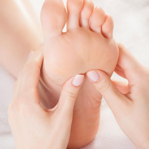 Una persona recibiendo un tratamiento de masaje de pies