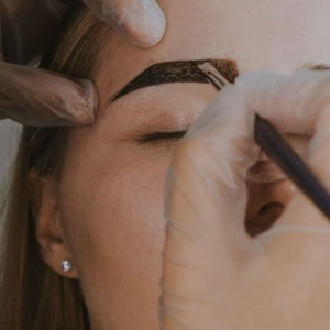 Una mujer recibiendo un tratamiento de estetica de cejas