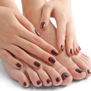 Una mujer acerca sus manos a sus pies para mostrar que todas sus uñas estan pintadas de negro