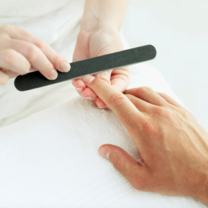 Un especialista limando las uñas a un señor