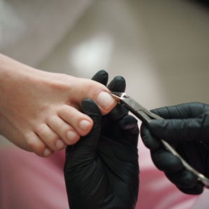 Un especialista cortandole las uñas a una persona